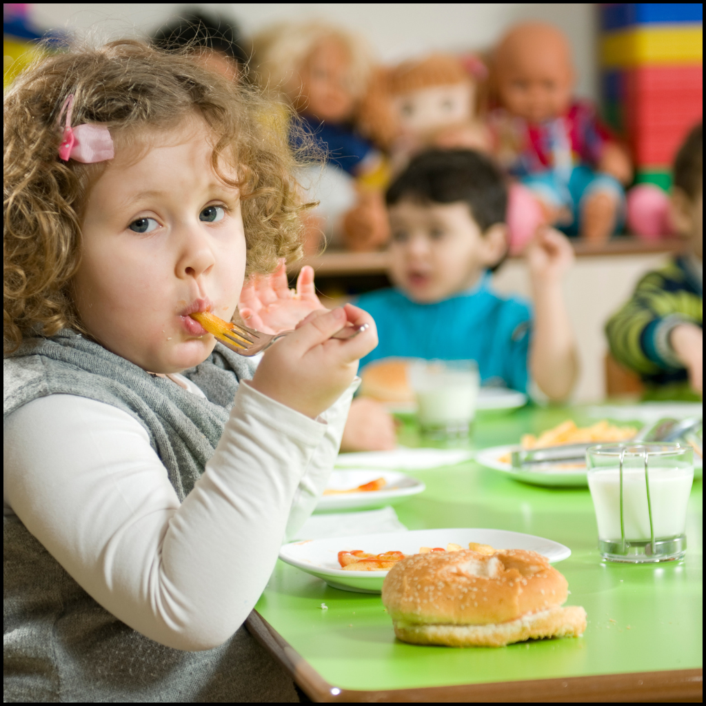 Snack Time and Speech Therapy: 5 Ways to Turn Crackers Into Language 1 Preschooler eats a snack at the classroom table while classmates enjoy snack time and speech therapy opportunities.